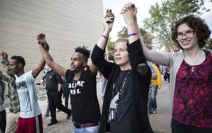 From the left; Najah Ibrahim, Ahmed Kewen, Courtney Kujala and Mathilda Young held hands raised during a unity rally at St. Cloud State University campus in St. Cloud on Tuesday.