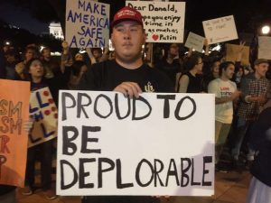 Weidknecht, 24, wore a red “Make America Great” cap and carried two signs, one of them saying, “Proud to be Deplorable.” 