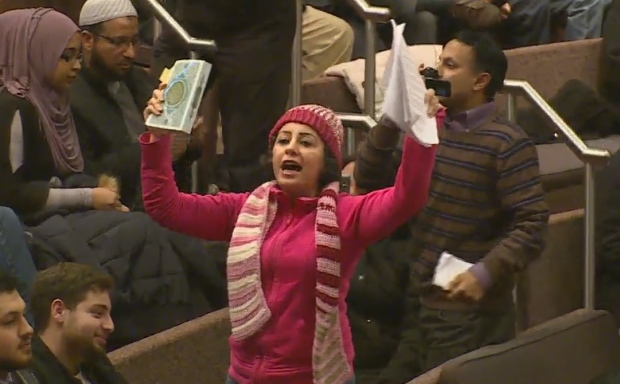 Protesters with anti-Islamic signs attended the meeting Tuesday and Peel Regional Police officers escorted this woman outside after she launched into a racially-charged outburst. (Mehrdad Nazarahari/CBC)
