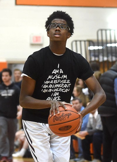PETE BANNAN-DIGITAL FIRST MEDIA Lower Merion's (34) Terrell Jones warms up wearing a shirt supporting refugees and immigrants before the Central League Boy's basketball Championship at Marple Newtown High School Tuesday evening.