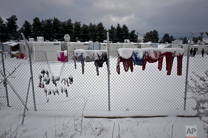 Laundry of Syrian refugees is covered with snow while hung on a fence at the refugee camp of Ritsona about 86 kilometers (53 miles) north of Athens, Tuesday, Jan. 10, 2017. The European Commission said conditions for refugees on islands and other camps where they are housed in tents despite severe cold weather, is "untenable." (AP Photo/Muhammed Muheisen)