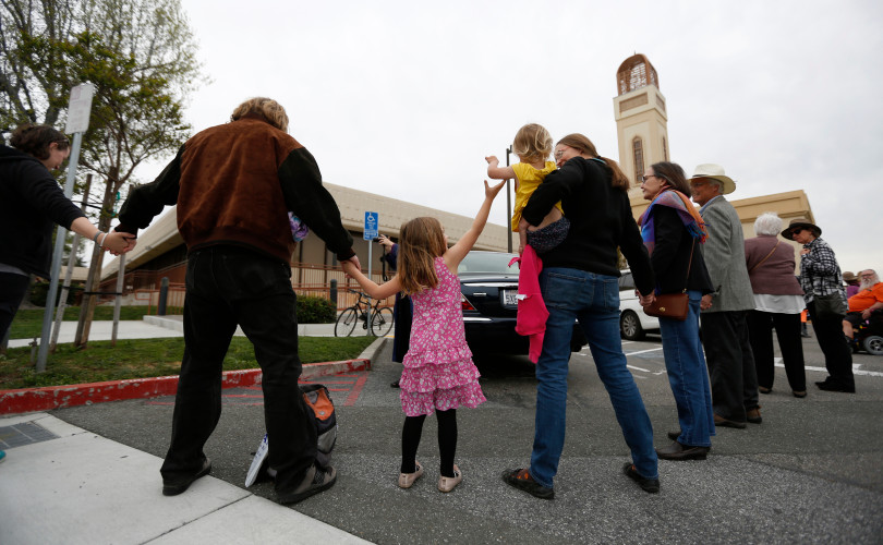 Evelyn Peters, center left, 4, from Mountain View, reaches for her sisters, Elena, 2, hand as they participate in "Hands Around the Mosque" with their parents Steve, left, and Teresa, outside of the Muslim Community Association in Santa Clara, Calif. on Sunday, March 19, 2017. (Nhat V. Meyer/Bay Area News Group)