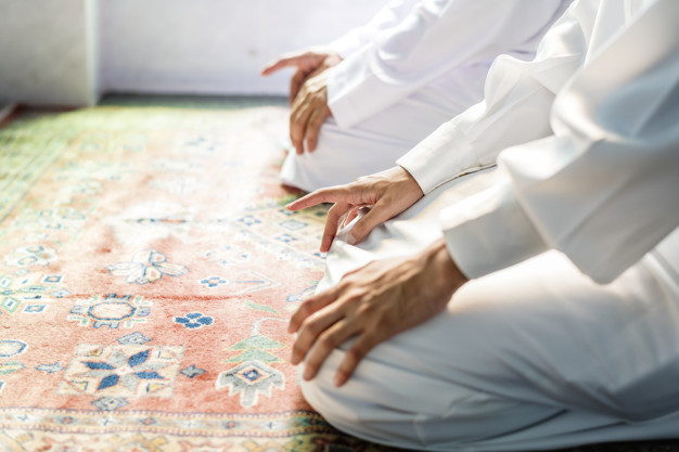 Muslim men praying in Tashahhud posture-What to Do If You Miss Prayer for a Long Time
