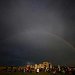 A rainbow is seen behind the Stonehenge stone circle as revellers watch the sun set on the eve of the Summer Solstice, in Amesbury, Britain, June-20