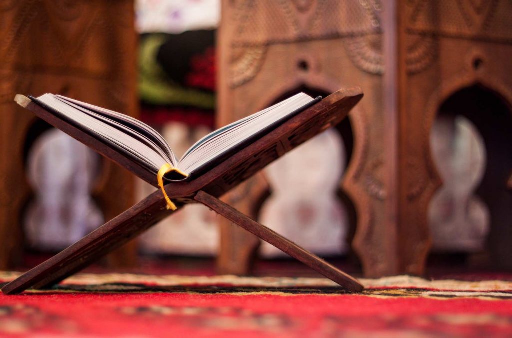 Quran on a wooden stand-Can We Gift Quran to Non-Muslims?