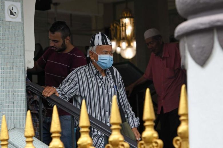 A man wearing a protective face mask leaves a mosque in Singapore on Feb 21, 2020. Both online and mosque collections will end on March 5.PHOTO: AFP