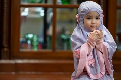Muslim kid girl wearing Hijab praying Dua