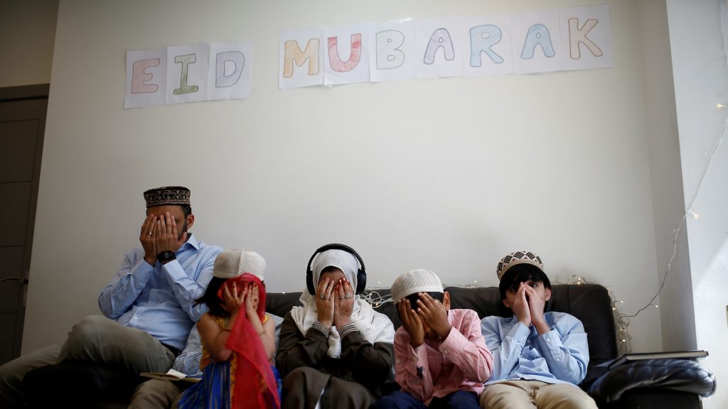A family offers Eid al-Fitr prayers at home to mark the end of the month of Ramadan in London. [Image- AP]