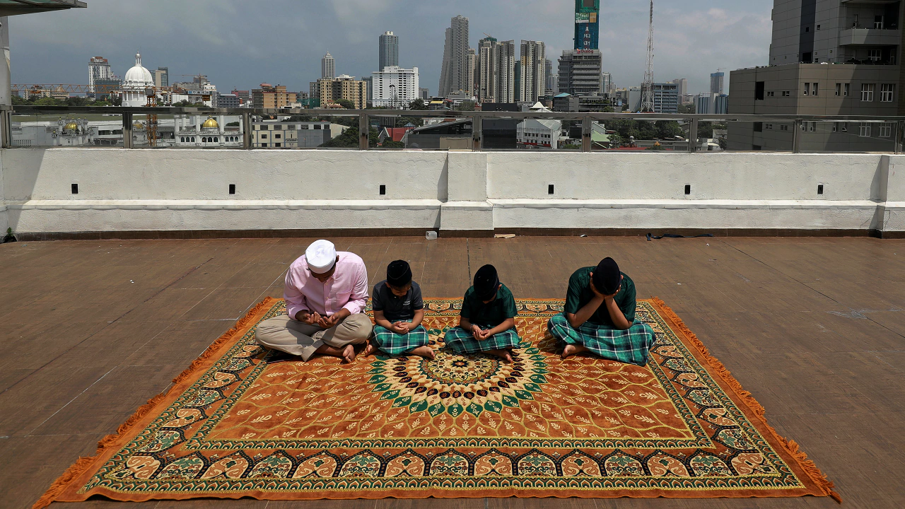 Kids of a Muslim family pray at a rooftop of their residence during the Eid al-Fitr prayers in Colombo, Sri Lanka (Reuters)