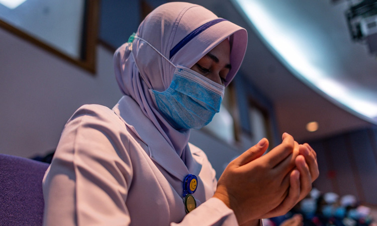 A staff nurse offers prayers during a ceremony to commemorate International Nurses Day at the Selayang Hospital, Malaysia, on Tuesday. AFP