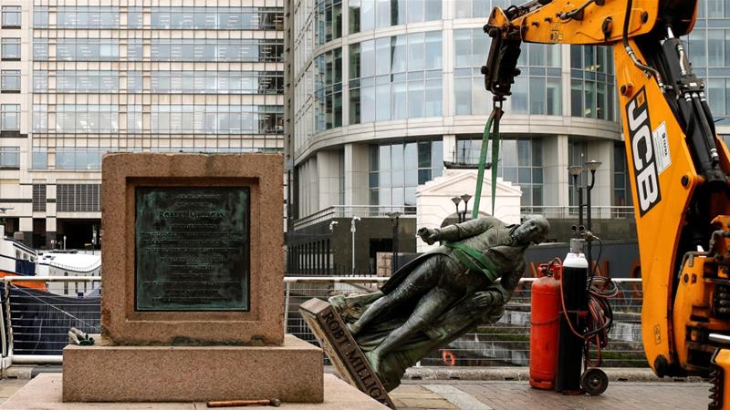 A statue of Robert Milligan is pictured being removed by workers outside the Museum of London Docklands [John Sibley/Reuters]