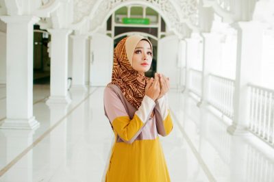 Muslim woman in headscarf and hijab prays