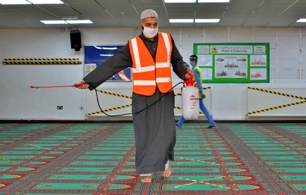 Essam Suffar applies cleaning spray on the prayer floor following prayers. This occurs after every prayer session.
