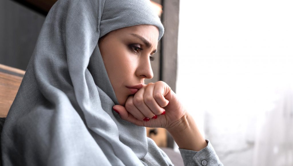 upset muslim woman in hijab with clenched fist