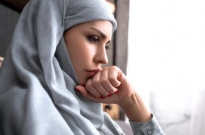 upset muslim woman in hijab with clenched fist