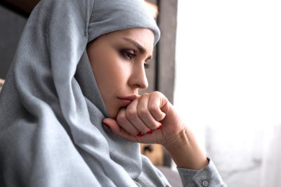 upset muslim woman in hijab with clenched fist