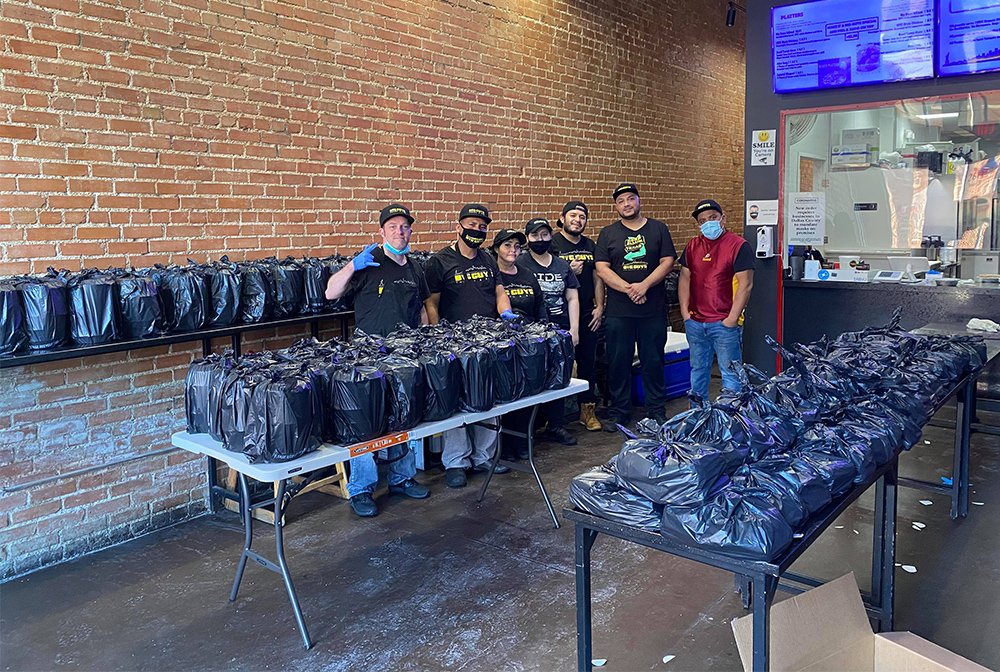 Staff at Big Guys Chicken and Rice, a halal restaurant in Dallas, pose with emergency hot meals prepared for storm victims. Photo courtesy of Big Guys