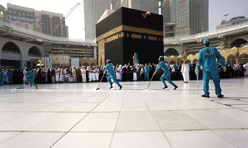 Workers sterilize the ground in front of the Kaaba, the cubic building at the Grand Mosque, in the Muslim holy city of Makkah, Saudi Arabia. (AP Photo/Amr Nabil)