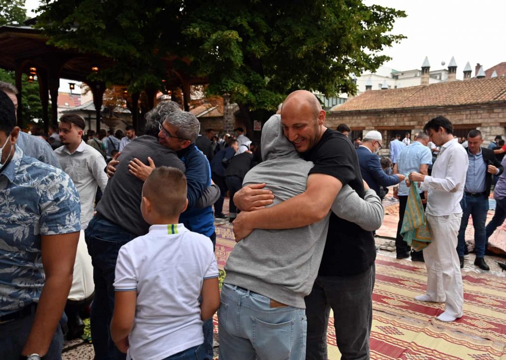 Bosnian Muslims share hugs after early morning prayer on Eid al-Adha, in front of Sarajevo’s central, Gazi-Husref Bey mosquePhotograph: Elvis Barukcic/AFP/Getty Images