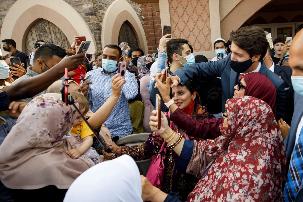 Canada’s Prime Minister Justin Trudeau takes selfies with community members at the Hamilton Mountain Mosque. THE CANADIAN PRESS/Cole Burston