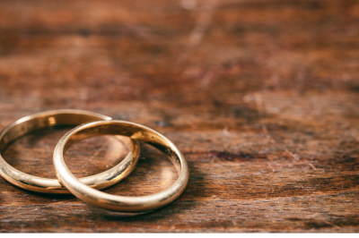 Two golden wedding rings on wooden background-Can I Marry a Non-Muslim Intending to Convert?