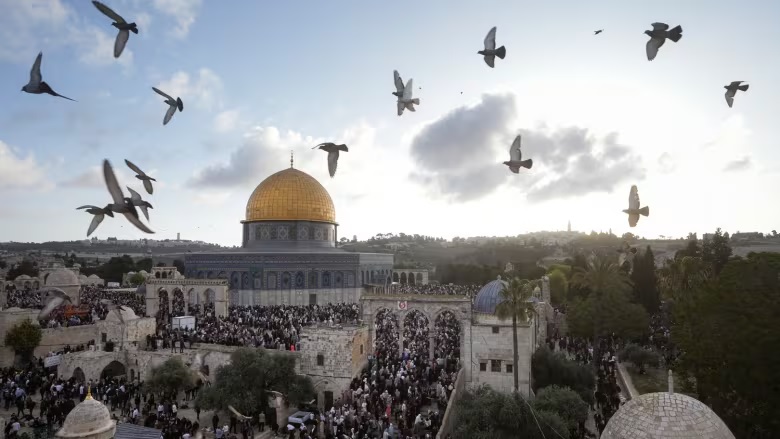 People attend `Eid Al-Fitr celebrations by the Dome of the Rock \in the Al-Aqsa Mosque compound in Al-Quds on Friday. (Mahmoud Illean/The Associated Press)