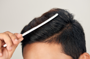 Young man combing hair