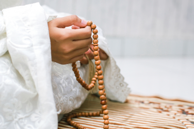 Muslim woman’s hand holding rosary to cound dhikr