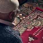 Muslim man praying in prayer rug -Time of Isha prayer