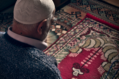 Muslim man praying in prayer rug -Time of Isha prayer
