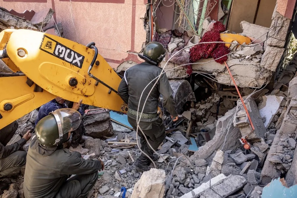 FADEL SENNA / AFP Rescuers use a small excavator to search for survivors