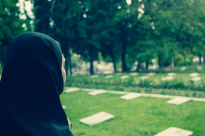 Muslim woman standing in graveyard-Can You Pray Janazah at the Cemetery?