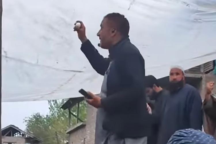 A videograb shows a man holding the egg auction for the mosque in Sapore, Kashmir.