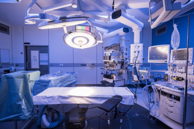 Empty hospital operating theatre with lighting over bed