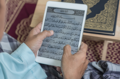 somene reading quran on tablet