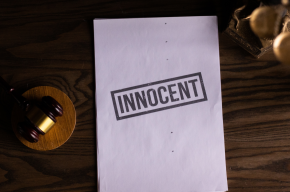 the word innocent written on a paper beside a gavel
