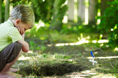 boy looking at gave of a pet