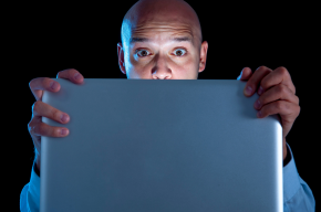 Addict man at computer laptop watching porn internet addiction concept